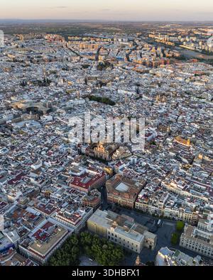 Vue aérienne de l'architecture ancienne de Séville baignée dans la lueur chaude du coucher du soleil, projetant de longues ombres sur les rues labyrinthiques, Séville, Andalousie Banque D'Images