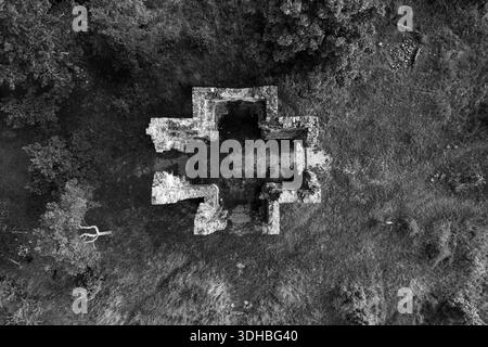 Vue drone de la chapelle de l'exaltation de la Sainte Croix à Bristev. Les ruines de pierre contrastent avec le paysage verdoyant, révélant sa signification historique et le passage du temps. Banque D'Images