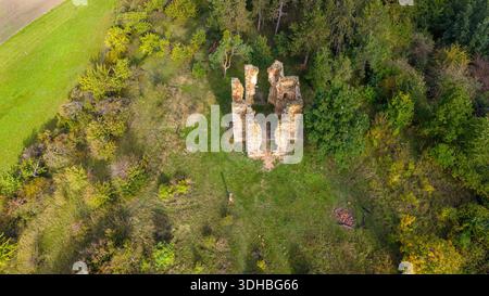 La vue du drone met en valeur les vestiges de la chapelle de l'exaltation de la Sainte Croix entourée d'une végétation luxuriante à Bristev. La nature récupère l'histoire dans le paysage tranquille. Banque D'Images