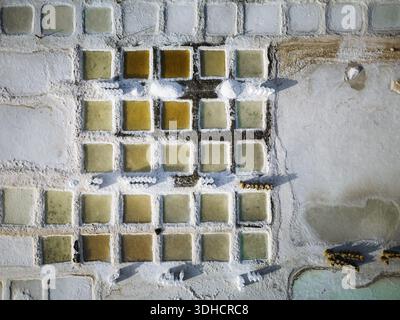 Vue aérienne des étangs de sel géométriques, leurs teintes pastel contrastant avec les cristaux de sel blanc et dur, créant un paysage surréaliste, Daghmar, Oman Banque D'Images