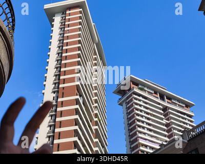 Vue en bas angle des immeubles modernes de grande hauteur contre un ciel bleu clair Banque D'Images
