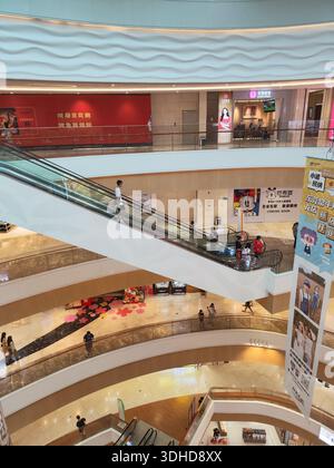 Vue intérieure d'un centre commercial moderne à plusieurs niveaux avec escaliers roulants et magasins Banque D'Images