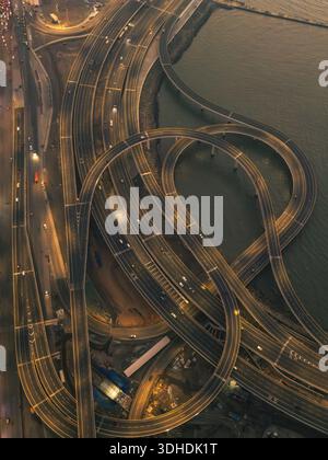 Vue aérienne d'un réseau complexe d'autoroutes illuminées et d'échangeurs près de la côte, créant une tapisserie urbaine fascinante de mouvement, Mumbai, Mahar Banque D'Images