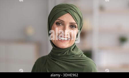 Portrait d'une femme musulmane senior souriante dans un hijab traditionnel en intérieur Banque D'Images
