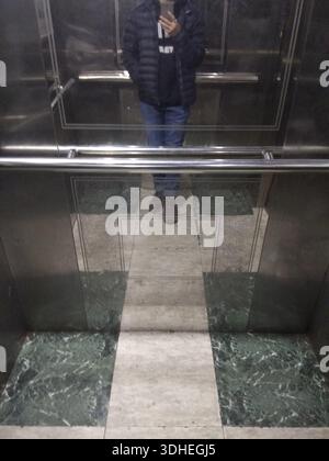 Personne prenant Selfie dans le miroir de l'ascenseur Banque D'Images