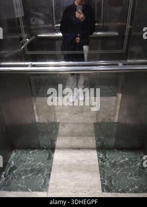 Reflet d'une personne prenant un Selfie dans un miroir d'ascenseur Banque D'Images
