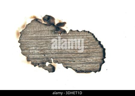Gros plan d'un trou brûlé avec des bords carbonisés sur un fond clair. Des planches de bois vieillies et altérées sont visibles à l'intérieur. Fond abstrait symbolisant fi Banque D'Images