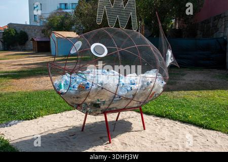 Porto, Portugal - 13 août 2025 : une grande sculpture de poisson fabriquée à partir de bouteilles en plastique est exposée dans un parc de Porto. Banque D'Images