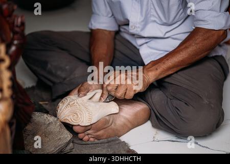 Mains d'artisan sculptant masque en bois dans Unawatuna close-up Banque D'Images