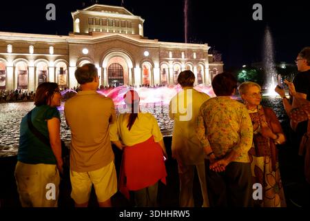 Touristes regardant le spectacle de la fontaine musicale la nuit sur la place de la République avec le Musée d'histoire illuminé à Erevan, Arménie, Europe de l'est Banque D'Images