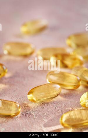 Gros plan de capsules d'huile de poisson oméga-3 ou softgels sur fond rose Banque D'Images