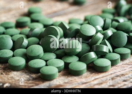 Comprimés d'algues spiruline sur une table en bois Banque D'Images