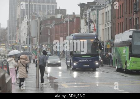 Dublin, Irlande - 21 janvier 2026 : vue de la scène de rue de la ville de Dublin alors qu'un bus Dublin Express voyage le long des quais par une journée couverte humide avec de longues périodes de fortes pluies dans la capitale irlandaise Banque D'Images