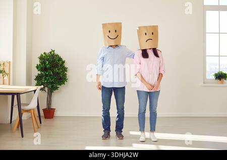 Couple avec des sacs en papier sur l'homme de tête soutenant la femme Banque D'Images