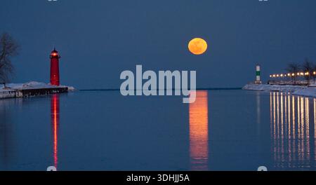 Pleine lune panoramique à l'heure bleue au-dessus du port de Kenosha avec deux phares et lumière de lune reflétant le calme lac Michigan, Wisconsin. Banque D'Images