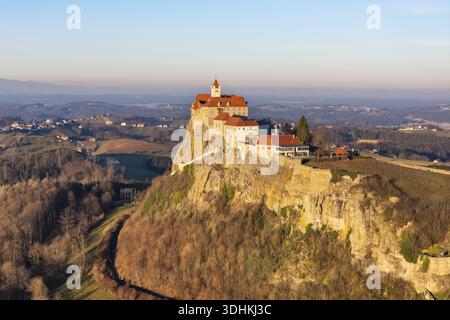 Vue aérienne du majestueux château de Riegersburg perché au sommet d'une falaise escarpée et ensoleillée, une forteresse médiévale au milieu des collines vallonnées, Riegersburg, sty Banque D'Images