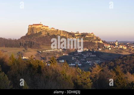 Vue aérienne du majestueux château de Riegersburg perché au sommet d'une colline volcanique, illuminé par la douce lueur du soleil couchant, Riegersburg, Styrie, Aus Banque D'Images