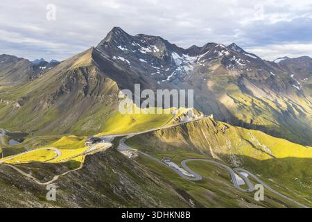 Vue aérienne de Grossglockner High Alpine Road serpentant à travers les montagnes escarpées et ensoleillées vers le majestueux sommet enneigé, Heiligenblut, S. Banque D'Images