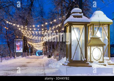 Oulianovsk, Russie - 14 février 2022 : énormes lanternes de Noël de rue dans l'illumination du soir. Rue enneigée dans les décorations de Noël. Banque D'Images