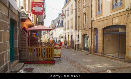 Ruelle pavée historique avec un crêperie, capturant une charmante scène typique de la ville française. Banque D'Images