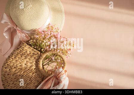 Chapeaux de paille, sac à main et fleurs. Élégant printemps-été Fashion Flatlay sur fond rose Banque D'Images