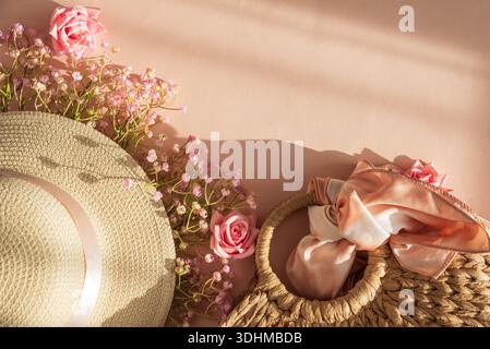 Chapeaux de paille, sac à main et fleurs. Élégant printemps été Fashion Flatlay sur fond rose Banque D'Images