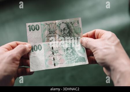 Billet de banque en couronnes tchèques tenu dans les deux mains. Concept de valeur de l'argent, pouvoir d'achat, petit budget, épargne de trésorerie et finances personnelles. Symbole de Banque D'Images