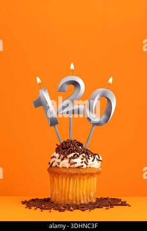 Numéro 120 bougie - conception de carte d'anniversaire sur fond orange. Cupcake Banque D'Images