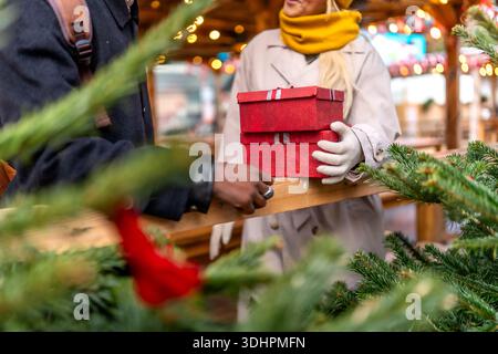 Couple échangeant des cadeaux de noël au marché festif de paris Banque D'Images