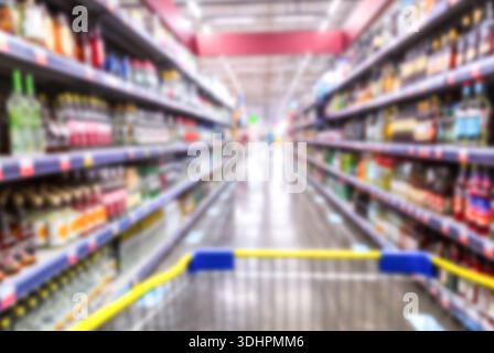 Arrière-plan flou. Diverses boissons alcoolisées sur les étagères dans un supermagasin. Flou abstrait dans le supermarché pour le fond Banque D'Images