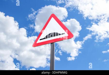 Triangle de signalisation de la vitesse bosse le ciel bleu. Avertissement panneau de signalisation vitesse bosse Banque D'Images