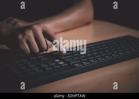 Gros plan de la main de l'homme appuyant sur la touche entrée du clavier de l'ordinateur. Banque D'Images