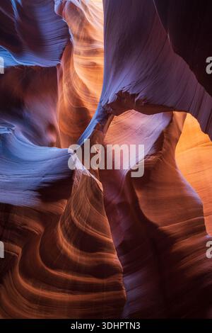 Vue des murs tourbillonnants en grès sculptés par le temps et la lumière, où les bleus froids rencontrent les oranges chaudes dans une danse d'ombres et de textures, Escalante, Utah, Uni Banque D'Images
