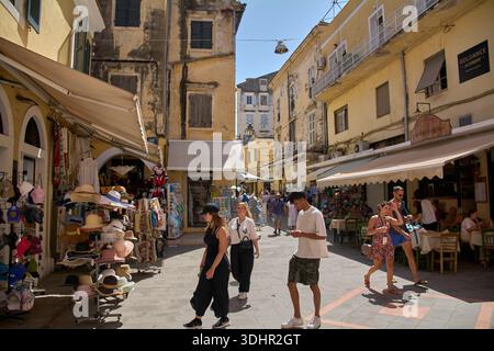 Corfou. Grèce - 22 janvier 2026 : les touristes se promènent dans une rue piétonne animée bordée de marchés et d'une architecture délavée par le soleil au cœur de Ke Banque D'Images