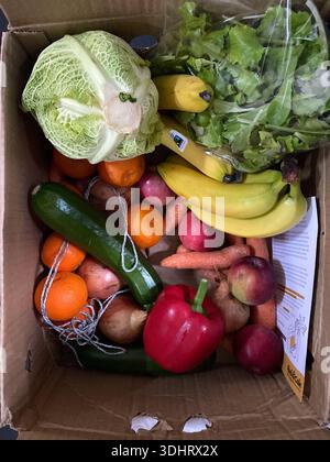 Une sélection saisonnière de fruits et légumes frais et biologiques dans une boîte en carton Banque D'Images