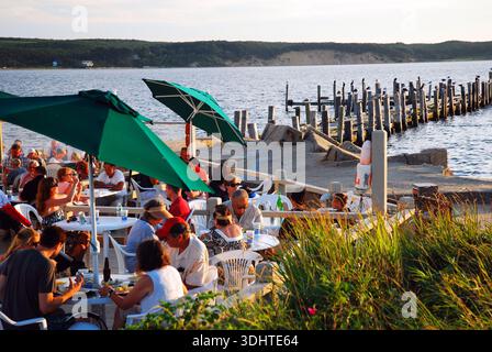 Les gens profitent d'un après-midi d'été à manger en plein air sur l'eau dans un complexe de Montauk, New York, sur long Island Banque D'Images