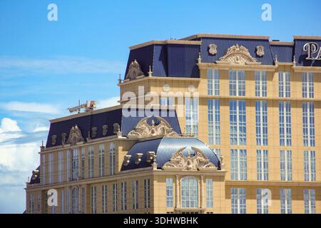 Vue extérieure détaillée d'un hôtel de luxe orné de sculptures en pierre et de toits mansardés bleus distinctifs sous un ciel bleu vif d'été. Banque D'Images