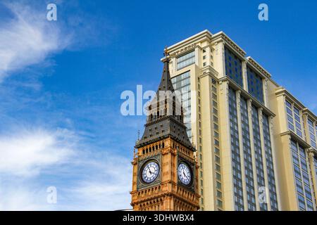 Contraste architectural avec une réplique de la tour de l'horloge Big Ben à côté d'un bâtiment d'hôtel de luxe moderne sous un ciel bleu vif d'été. Banque D'Images