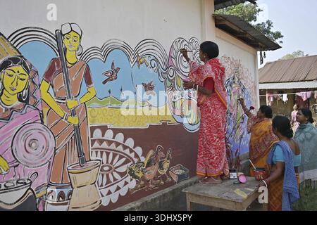 Agartala, Tripura, Inde, 12-01-2026 : des femmes peignent Alpona, sur le terrain avant le festival hindou Makar Sankranti dans le village de Lankamura à Agartala. Banque D'Images