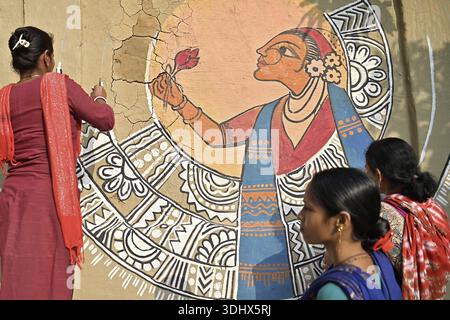 Agartala, Tripura, Inde, 12-01-2026 : des femmes peignent Alpona, sur le terrain avant le festival hindou Makar Sankranti dans le village de Lankamura à Agartala. Banque D'Images
