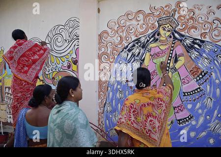 Agartala, Tripura, Inde, 12-01-2026 : des femmes peignent Alpona, sur le terrain avant le festival hindou Makar Sankranti dans le village de Lankamura à Agartala. Banque D'Images