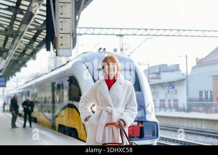 Voyageur d'affaires mature calme attendant le train sur le quai Banque D'Images