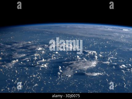 Le lever du soleil projette de longues ombres depuis les nuages à travers la mer des Philippines, vu de l'espace. Photographié depuis la Station spatiale internationale le 13 juillet 2020. Une version optimisée d'une image originale de la NASA : crédit : NASA Banque D'Images