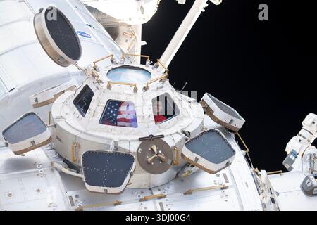 Nicole Mann, astronaute de la NASA et ingénieur de vol de l'expédition 68, regarde à travers une fenêtre de coupole à bord de l'ISS, affichant le drapeau américain tout en observant la Terre depuis son orbite. Photographie prise depuis la Station spatiale internationale le 2 janvier 2023. Une version optimisée d'une image originale de la NASA : crédit : NASA. Utilisation éditoriale uniquement - aucune approbation commerciale. Banque D'Images
