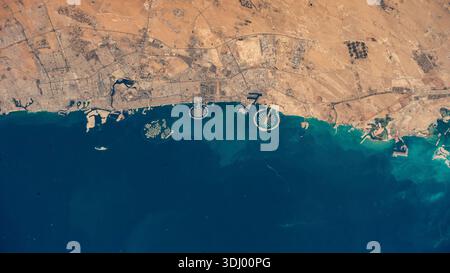 Côte des Emirats Arabes Unis, Dubaï et archipel arjpgicial des îles des palmiers vu d'orbite. Palm Jumeirah (centre-gauche) et Palm Jebel Ali (centre-droite). Les îles ont été construites à l'aide de millions de mètres cubes de sable pour créer des terres en forme de palmiers s'étendant dans le golfe Persique. Un autre ensemble d'îles arjpgiciales, connues sous le nom de « les îles du monde », en forme de carte du globe, peut être vu à gauche de Palm Jumeirah. Une photographie prise depuis la Station spatiale internationale le 29 janvier 2025 une version optimisée d'une image originale de la NASA : crédit : NASA Banque D'Images