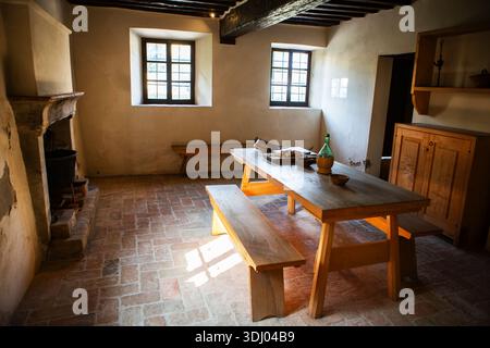Salle à manger rurale historique avec plancher de brique meubles en bois poutres épaisses lumière du soleil douce style de vie traditionnel intérieur chaleur patrimoine liv Banque D'Images