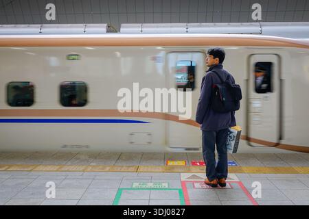 Tokyo, Japon - 2 janvier 2016. Homme asiatique debout sur la plate-forme attendant le Shinkansen, emblématique gare de Tokyo, Japon. Banque D'Images