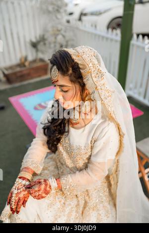 « Mariée traditionnelle d'Asie du Sud en tenue de mariage crème-or avec Mehndi et bijoux » Banque D'Images