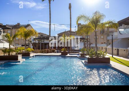 Piscine résidentielle contemporaine entourée de palmiers, eau claire et atmosphère relaxante ensoleillée Banque D'Images