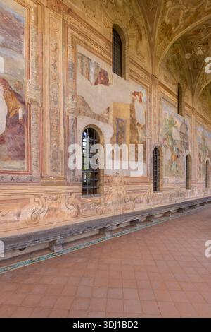 Naples, Italie - 27 juin 2021 : cloître Santa Chiara, vue sur le couloir sous les arcades et fresques colorées décorées sur les murs Banque D'Images
